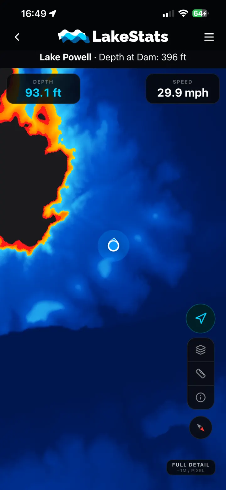 The Compass depth map in the LakeStats app on Lake Powell, shading shallow water red and orange and deep water blue, with the boat's position and current depth shown.